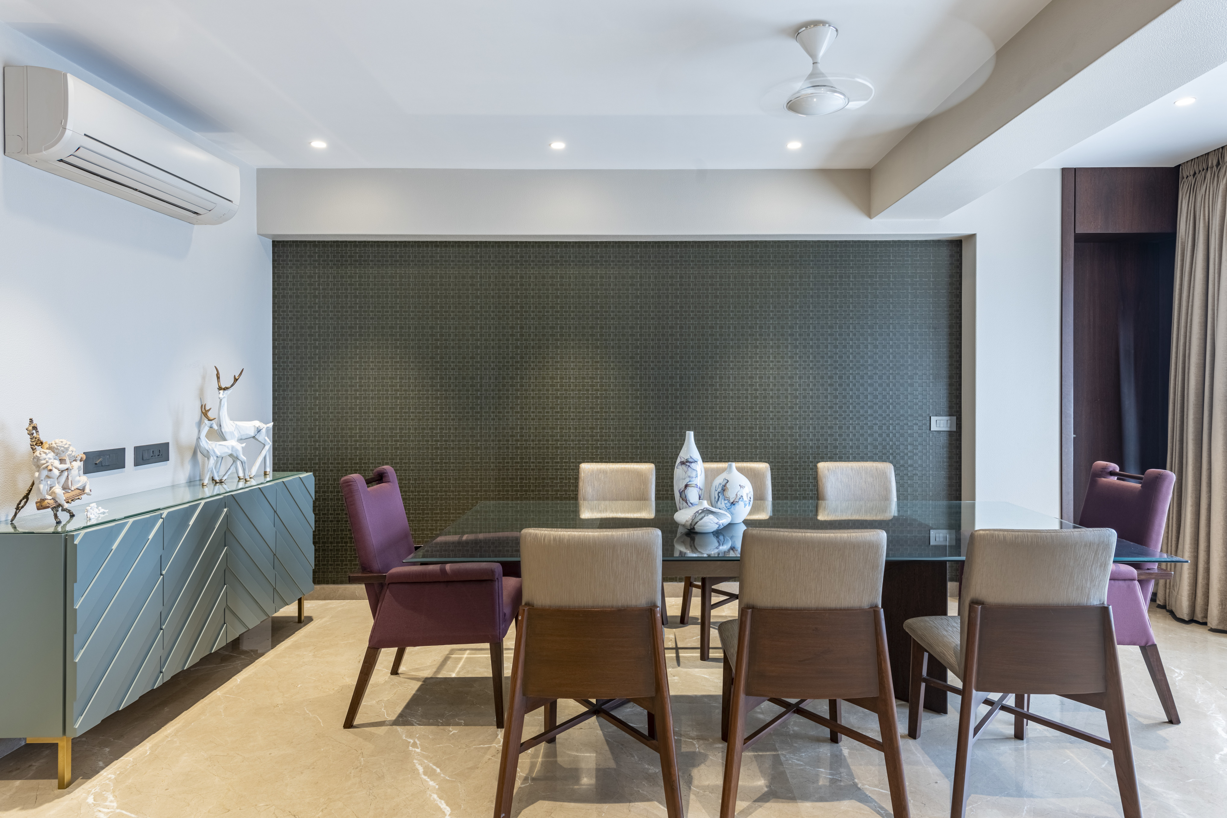 Dining room with a chevron walnut sideboard, glass-topped table, and carefully specified objects by Porcelain Sheer.